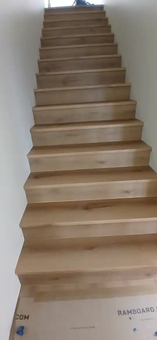 Finished wood-look stair treads running up a staircase