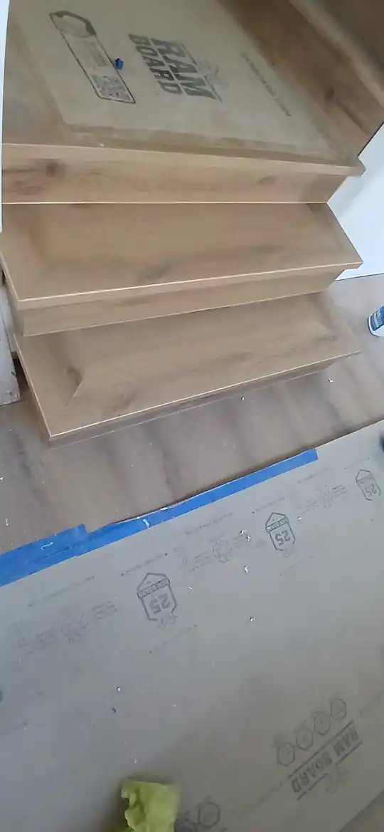 Stair treads being fitted over protective board during an installation