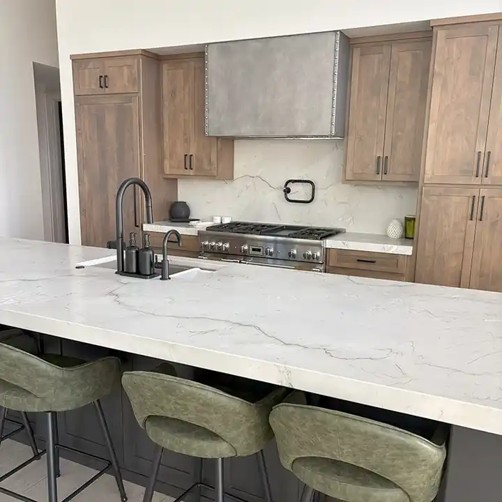 Marble-look quartzite kitchen island with a double edge and green stools