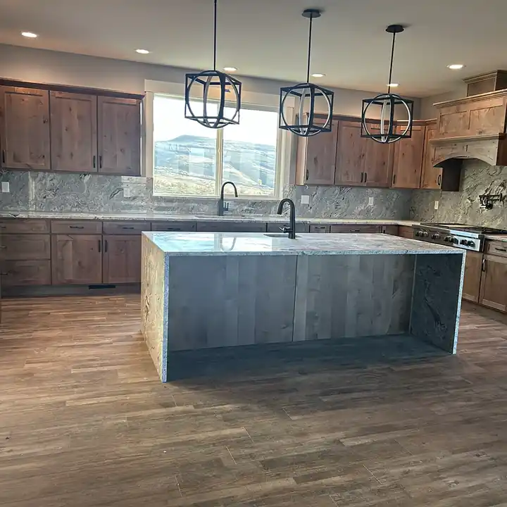 Custom granite kitchen with a waterfall island and full-height backsplash