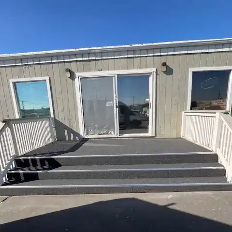Gray outdoor carpet installed on a commercial entry deck and stairs