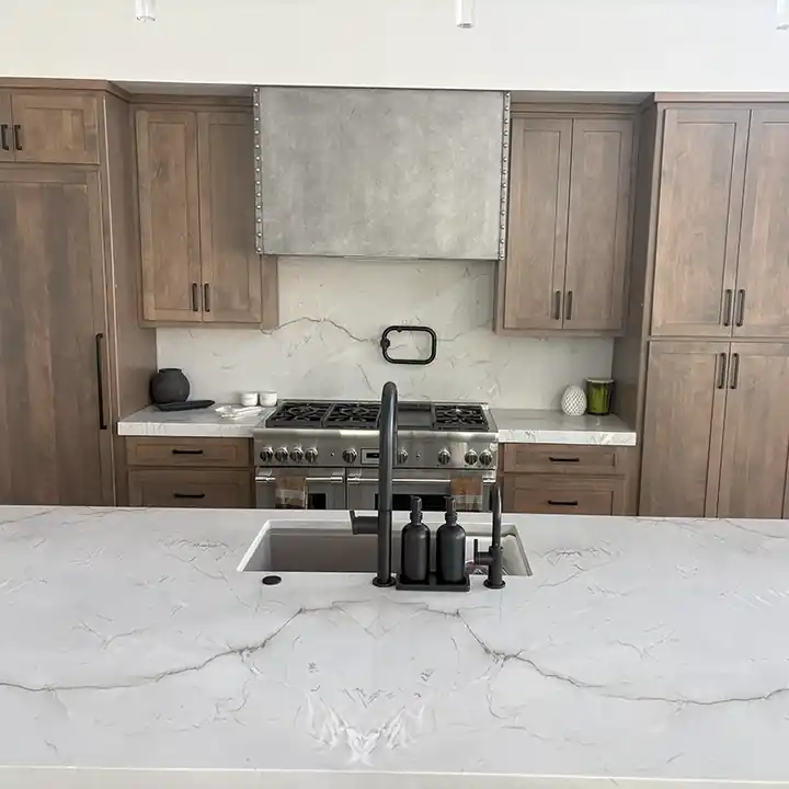 Quartzite island with a full slab backsplash behind the range