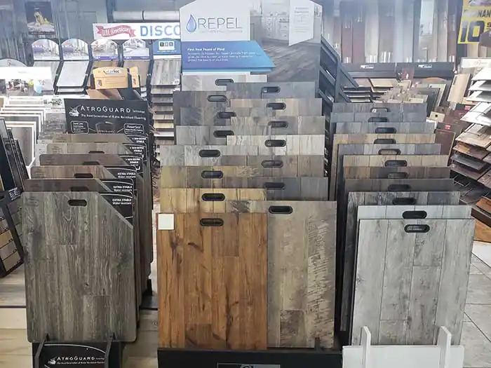 Racks of wood-look plank samples in the All American showroom