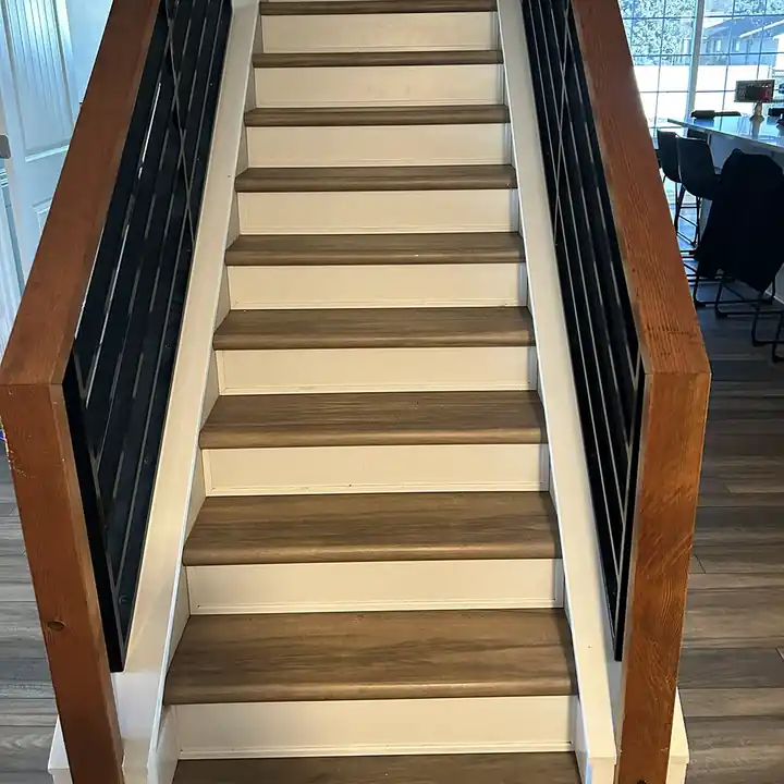 Staircase with wood-look treads, white risers and a black rail