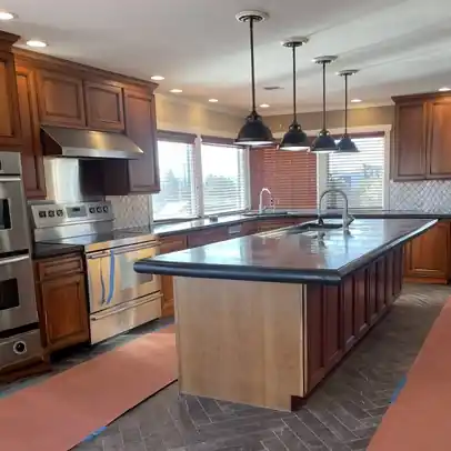 The kitchen before: dark concrete countertops and worn tile